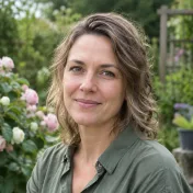 Portret van een vrouw met kort grijs haar in een tuin met rozen op de achtergrond