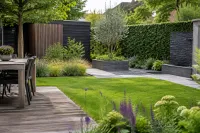 Moderne achtertuin met houten terras, strak gazon, verhoogde plantenbakken en siergrassen