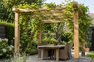 Houten pergola met klimplanten boven tuintafel en rieten stoelen in zonlicht